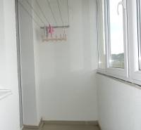 A glazed balcony in a 3-room apartment with a view of the city district.