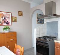 A kitchen in a 3-room apartment with a gas stove and wooden decor furniture.