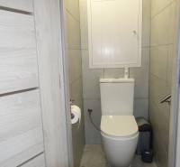 A bathroom in a 3-room apartment with tiled floors and gray walls.