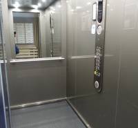 Interior of an elevator with a control panel and a mirror in a 3-room apartment.