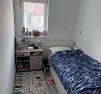 Children's room with a bed, window, and rug in a 4-room apartment.