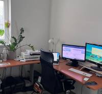 Home office with a computer and wooden decor flooring in a 4-room apartment.