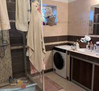 A bathroom in a 4-room apartment with a washing machine and a shower.