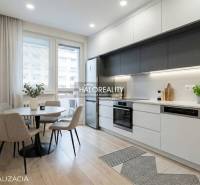 Dining area with a round table and a kitchen with a unit in a 3-room apartment.