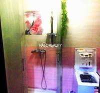 A bathroom in a 2-room apartment with a shower and a washing machine, color-coordinated in pink.