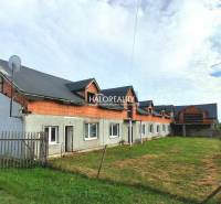 Commercial premises in Tibava, an unfinished building with a grassy area and a fence.