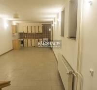 Spacious kitchen and dining room in a family house with tiles and bright lighting.