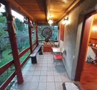 An outdoor terrace with wooden railing and a garden by the cottage, offering tranquility.