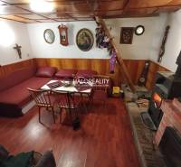 Rustic cottage, wooden ceiling, fireplace, comfortable sofa, traditional interior, cozy atmosphere.