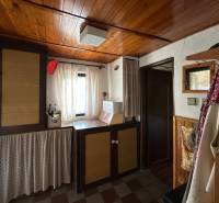 Interior of a family house with a wooden ceiling and curtains, a cozy nook with decorative elements.