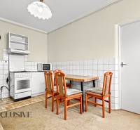 Kitchen in a family house with a dining table, chairs, and a stove.