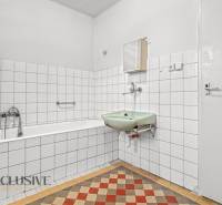 A bathroom in a family house with a classic sink and bathtub with white tiles.