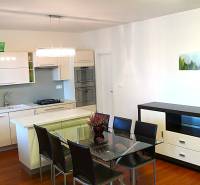 Kitchen in a 4-room apartment with a dining table and wood-patterned flooring.