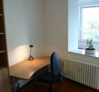 A workspace with a desk, shelf, and view in a 4-room apartment.