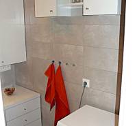 A bathroom with a washing machine and storage space in a 4-room apartment.