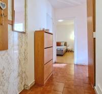 A hallway in a 2-room apartment with a wooden decor floor and furniture.