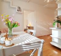 Dining room in a 2-room apartment with flowers on the table, floor with wood decor.