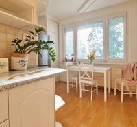 A bright kitchen with a dining area and a wooden decor floor in a 2-room apartment.