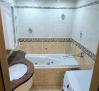 Bathroom in a 3-room apartment with a bathtub and a washing machine, decorative tiles.