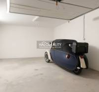 A garage in Borčice with a parked retro vehicle, smooth concrete floor, white walls.