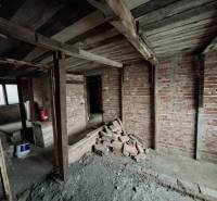 Unfinished interior with brick walls and wooden ceiling in a family house.