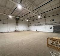 Industrial hall with high ceiling, lighting and empty space, suitable for offices.