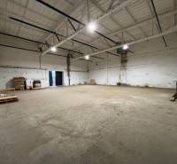 Spacious offices with high ceilings and a pallet jack on a concrete floor.