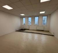 Offices with white walls, floors, and windows, waiting to be completed.