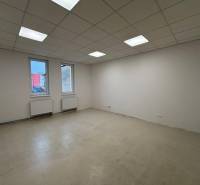 An empty office with white walls and ceiling panels, without flooring with a wooden decor.
