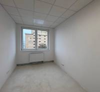 White office with a radiator and a view through the window.