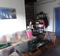 Living room in a family house with a colorful sofa, coffee table, and wall painting.