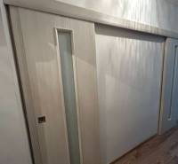 Sliding doors with glazing, floor with wood decor, interior of a studio apartment.
