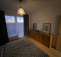 Bedroom with a dresser and a lamp, wooden decor flooring in a 2-room apartment.