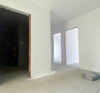 Interior construction in a family house with white walls and an unfinished floor.