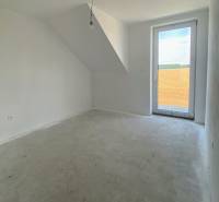 An empty room in a family house with a concrete floor and a skylight overlooking the fields.