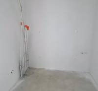 An empty room in a family house with a concrete floor and prepared wiring.