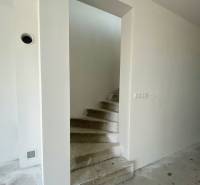 Concrete staircase and neutral wall in a family house, waiting for completion.