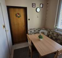 Dining area with a table and benches in a 3-room apartment.