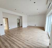 A spacious room with a wood-decorated floor and white walls, family house.