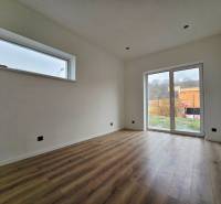 The interior of a family house with a wooden decor floor and a large window.