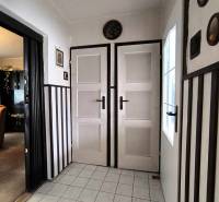 Interior of a family house with white doors, tiles, and dark wall cladding.