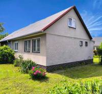 A family house in Nováky with a white facade and a garden full of greenery.