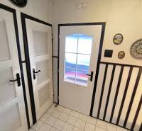 Interior of a family house with white doors, wall decorations, and tiles.