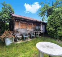A wooden cottage with plastic chairs in the garden of a family house in Nováky.