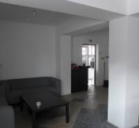 Living space with gray sofas, a coffee table, and tiled flooring in warehouses and halls.