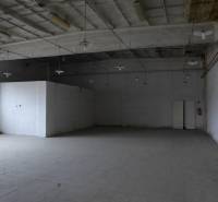 Industrial warehouse interior with high ceiling and concrete floor.