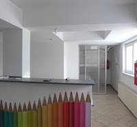 Interior of warehouses and halls with a reception desk decorated with colored pencils and a fire hydrant.