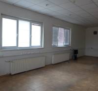 An empty room with wall radiators and tiles in warehouses and halls.