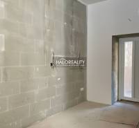 A bright room with unfinished walls in a family house with an entrance door.