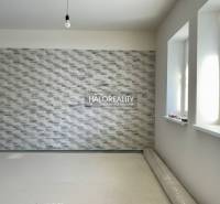 Interior of a family house with a textured wall and an uninstalled wooden decor floor.